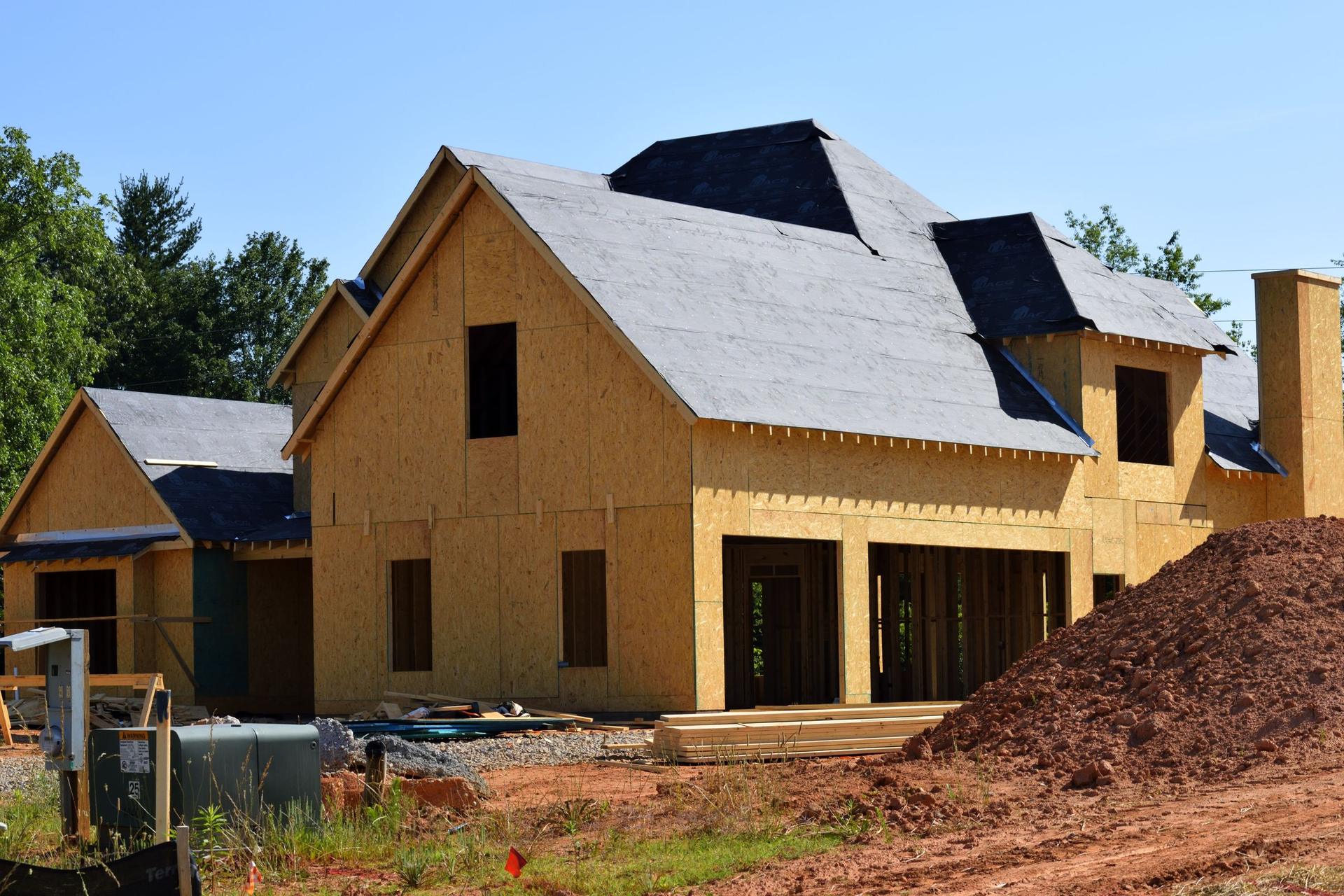 A house under framing on a lot still at rough dirt