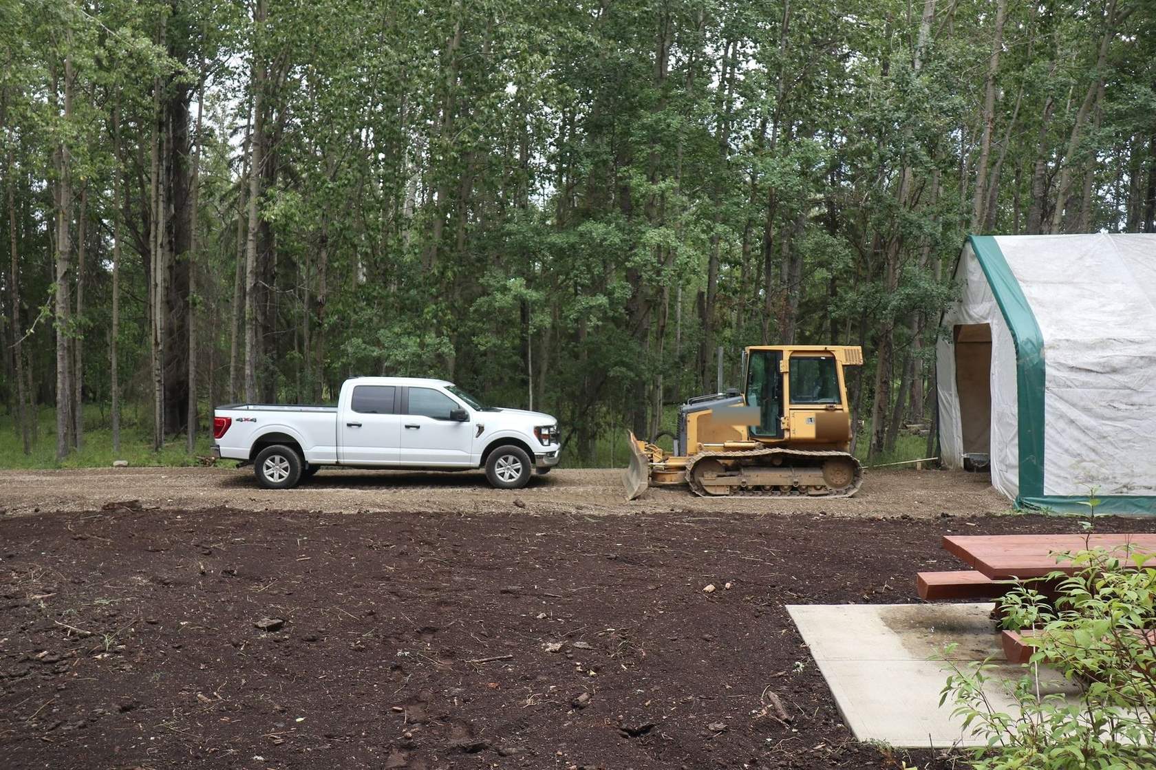 A contractor pickup and dozer on freshly graded ground